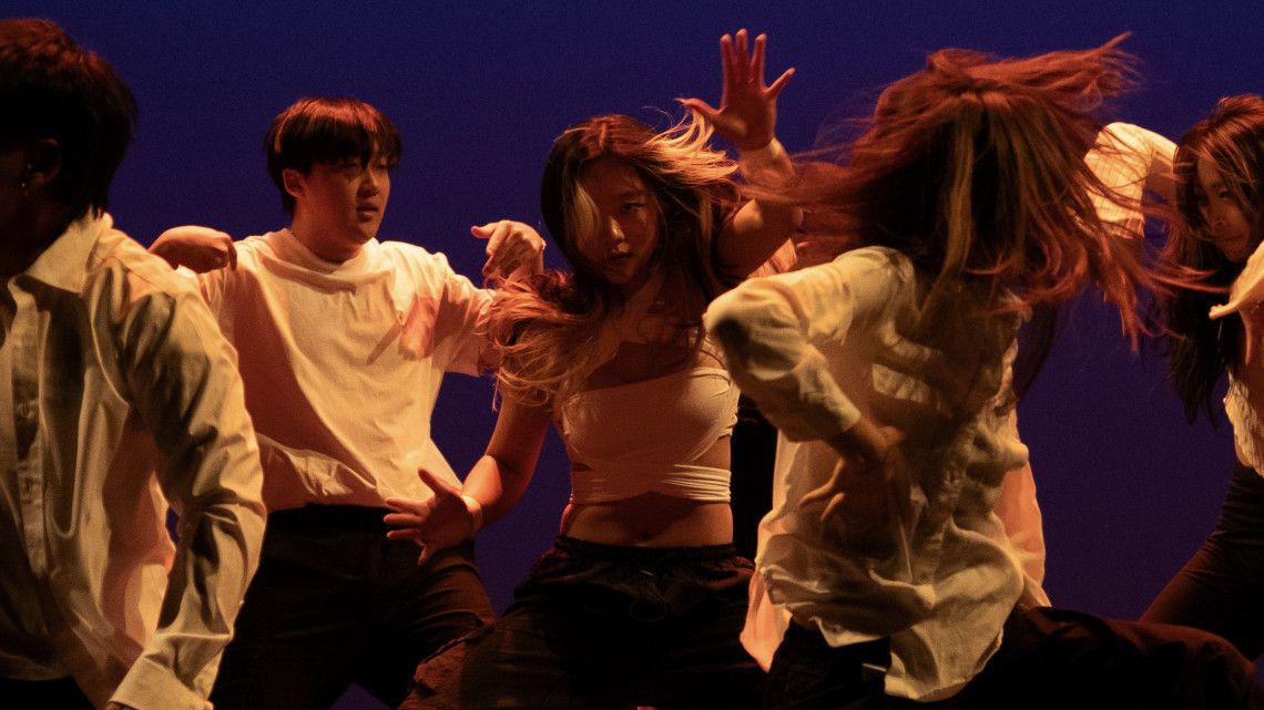 Jackie No is in the center of a group of students dancing. 